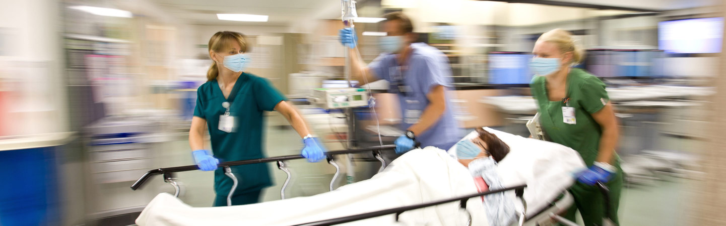 Sjukvårdspersonal springer i korridor med patient i säng