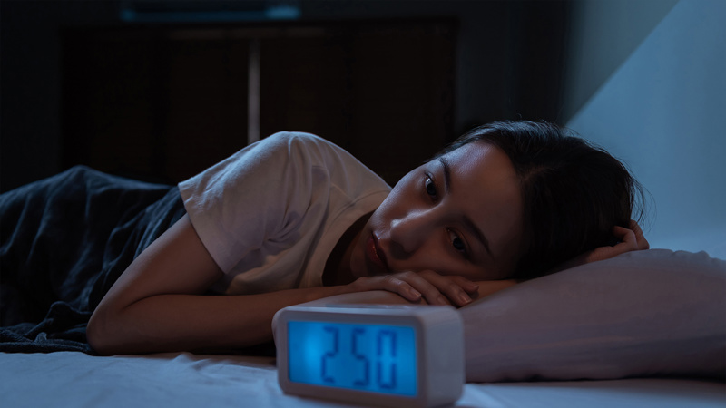 Teenager lying awake in her bed, in the middle of the night.