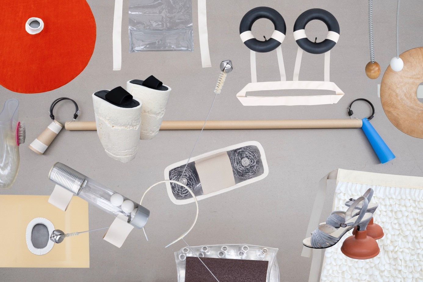 A collection of artistic objects and materials arranged on a grey surface, designed to be experienced through different senses. 